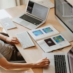 A person writing multilingual articles with two laptops