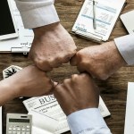 Group of four fist-bumping