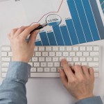 A person holding a magnifying glass to a investment graph