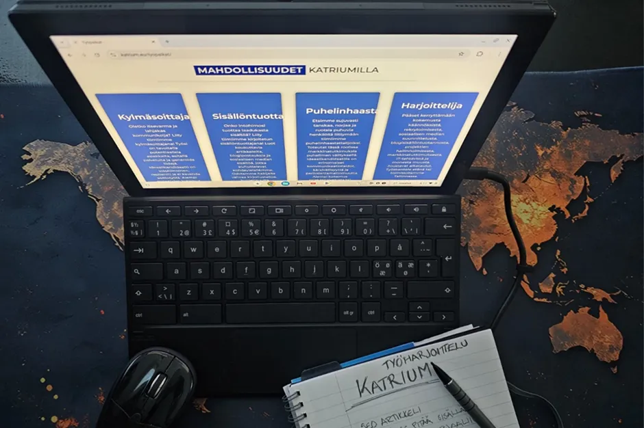 Kuvassa kannettava tietokone, jossa näkyy työharjoittelusivu ja muistivihko, johon on kirjoitettu muistiinpanoja harjoittelusta.