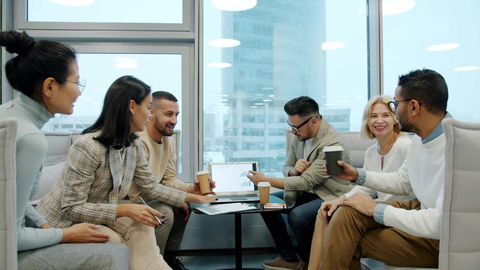 Team of professionals discussing work and collaborating in a modern office setting