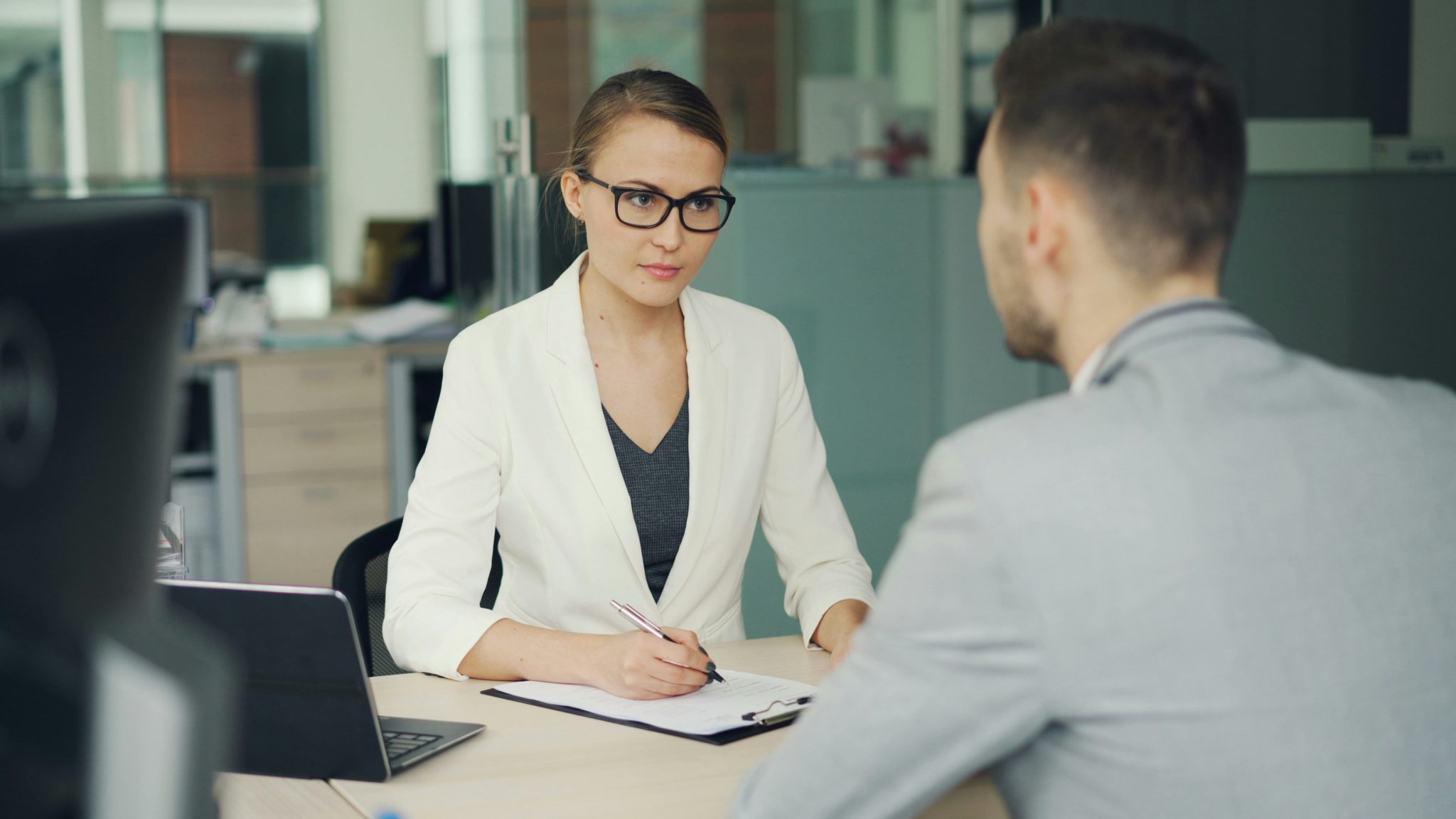 Recruiter conducting a talent sourcing interview with a job candidate in a modern office setting.