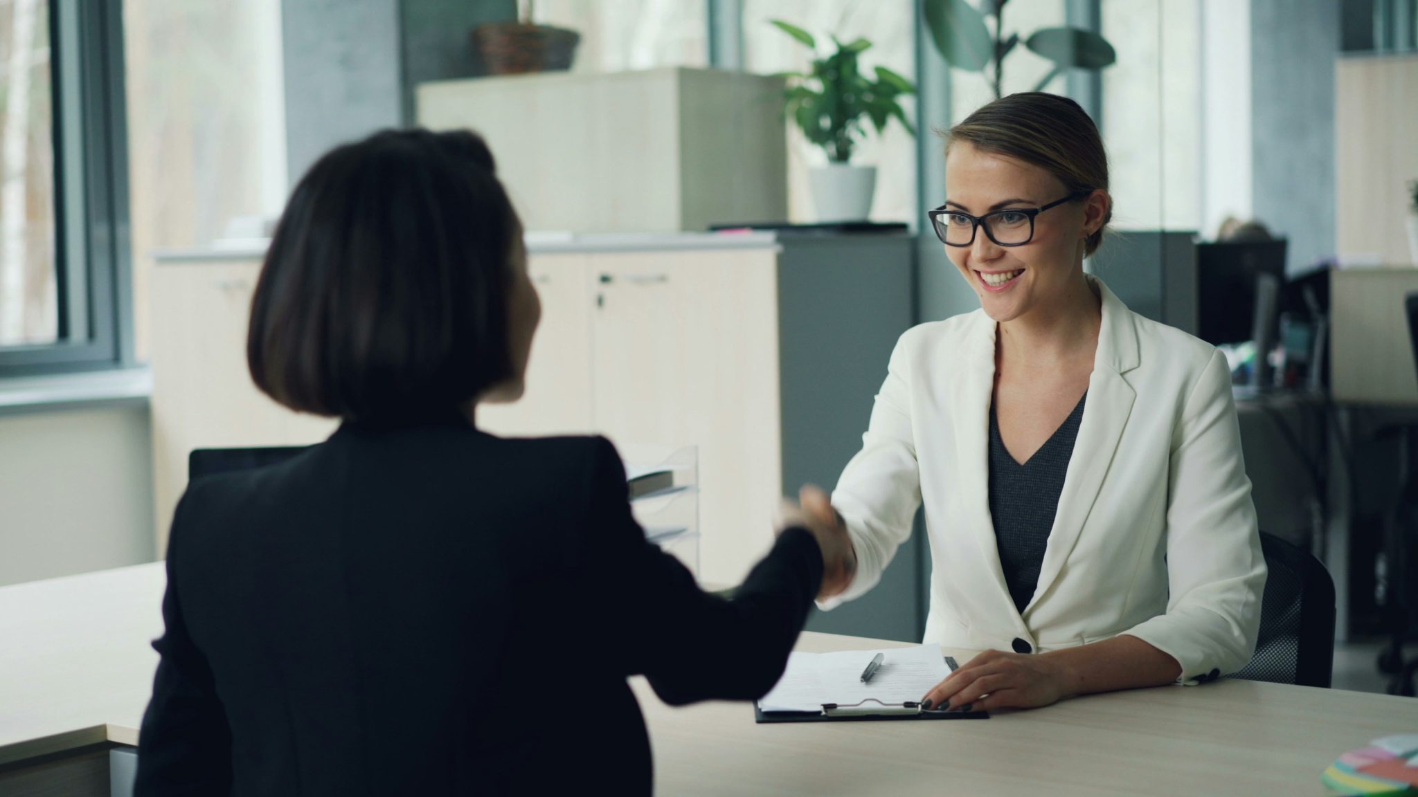 Professional talent sourcing meeting between recruiter and candidate in a modern office environment.